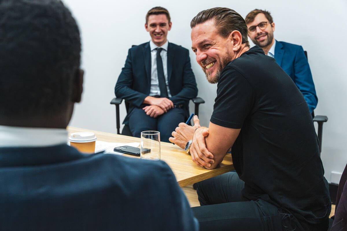 Candid close-up of an attendee laughing across a boardroom table